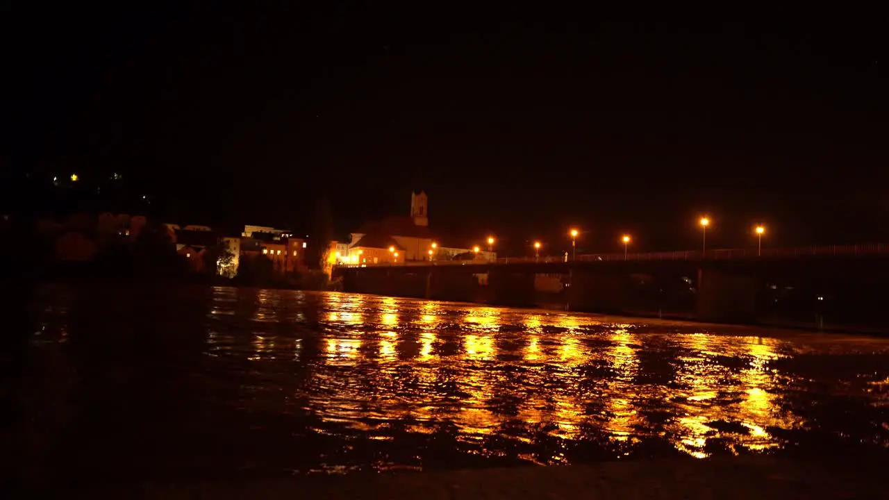 River flowing at night with city lights from bridge reflected on water in Passau Germany