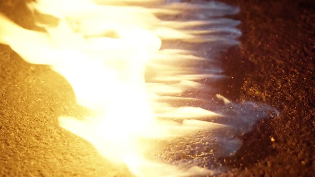 Close up shot of a flame on the ground on a road street at night 25p