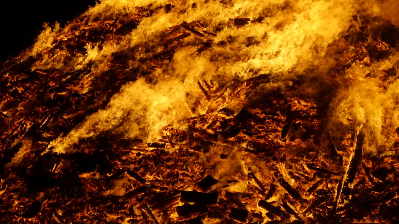 A mid mostly static shot of a huge bonfire burning in slow motion shot in 180fps