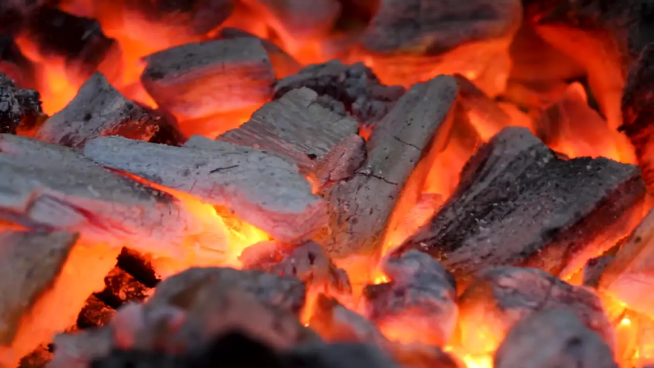 a close up of hot charcoal burning in a grill red and flaming embers grill concept