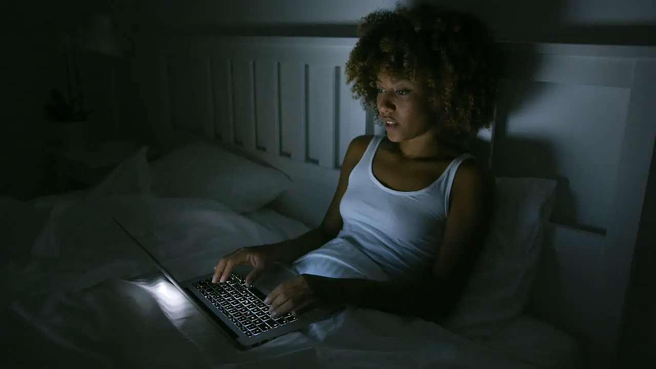 Young woman using laptop in night