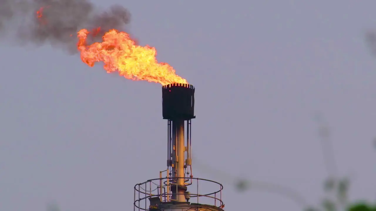 A towering gas refinery structure spews fiery flames into the atmosphere