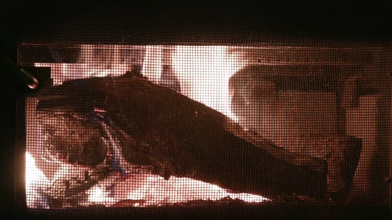 Wood burning and crackling in old cast iron fireplace in cabin