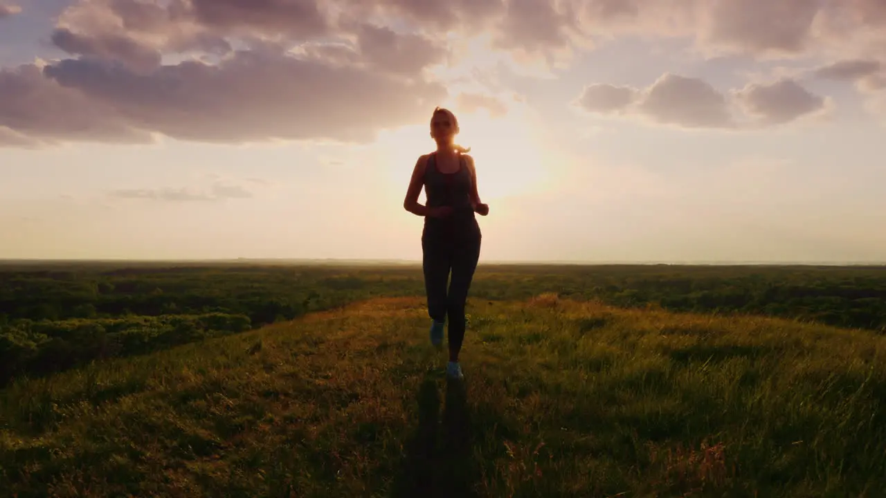 Athletic Middle-Aged Woman Runs At Sunset 1