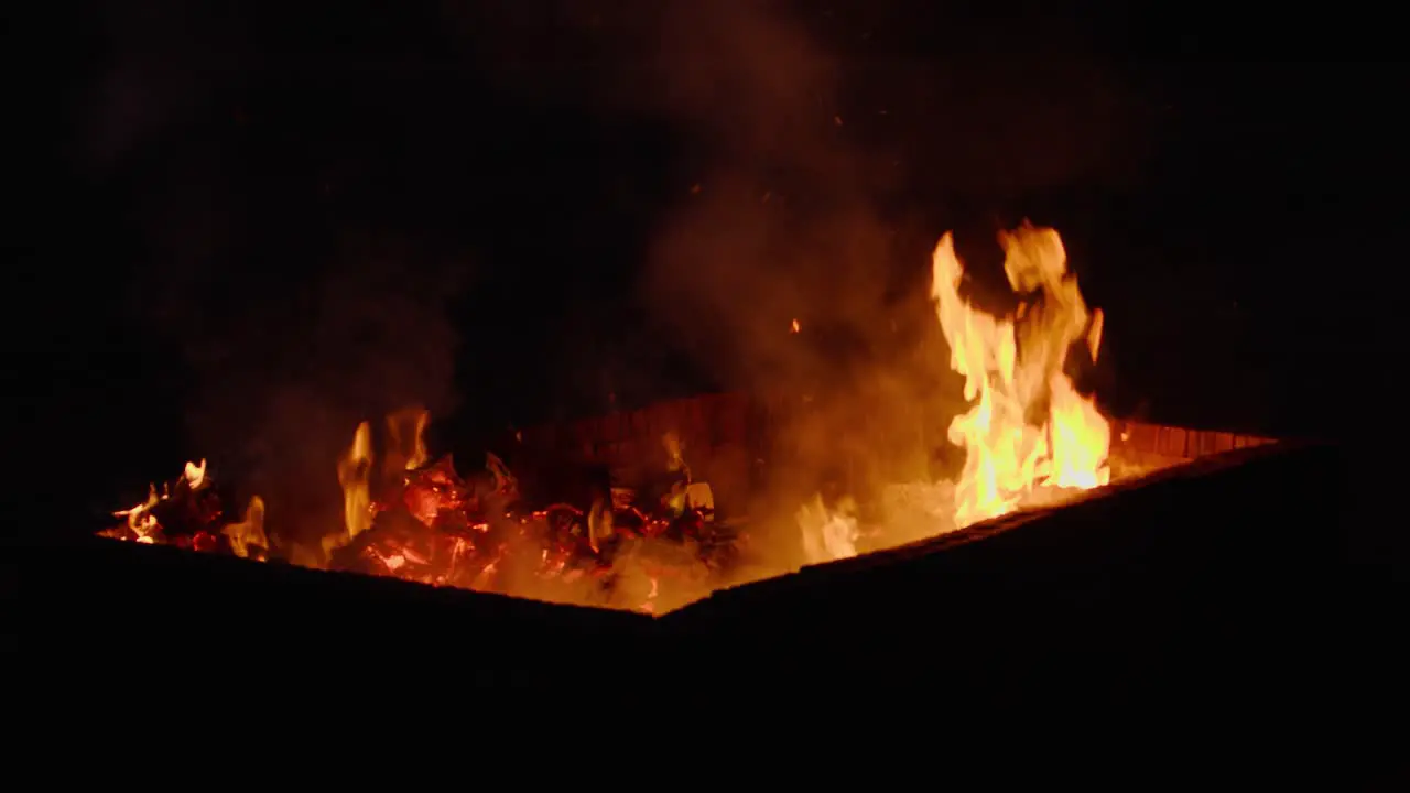 Shot of a fire pit burning trash at night