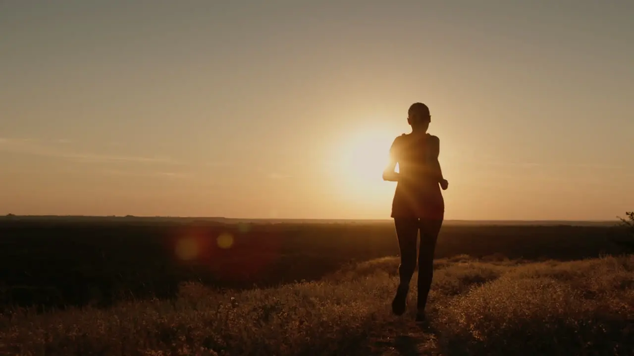 Athletic middle-aged woman runs at sunset