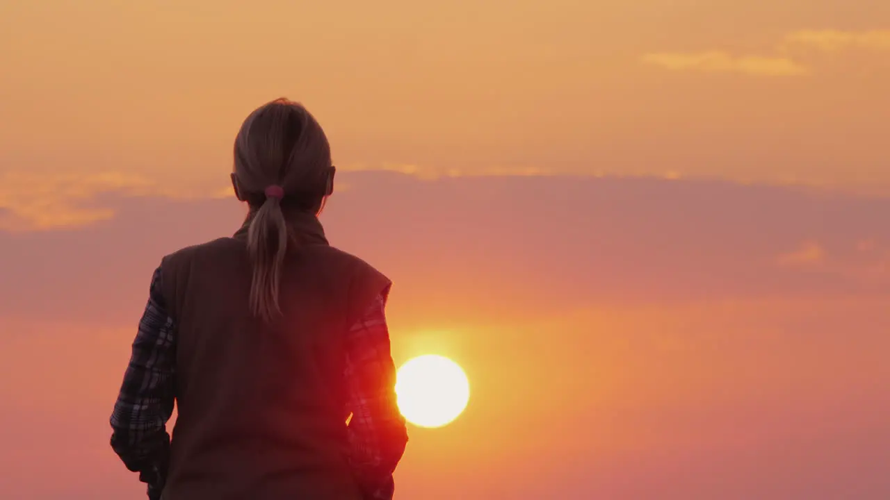 Silhouette Of A Middle-Aged Woman Who Goes To The Setting Red Sun