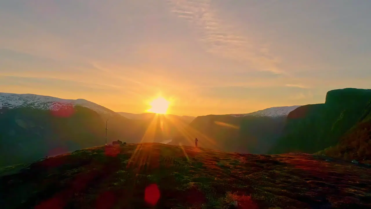 Aerial drone shot flying over mountain top revealing beautiful scenery of Aurland Norway at sunrise