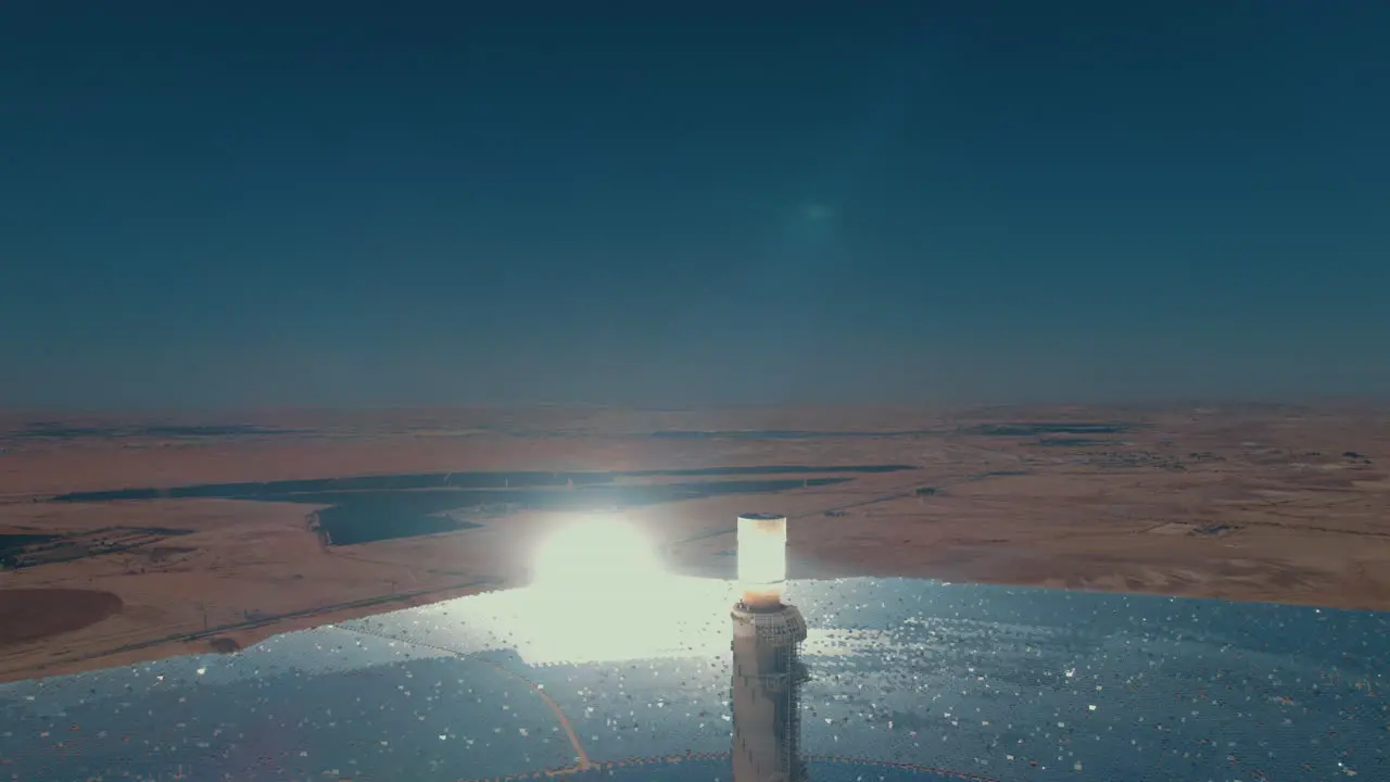 Solar power tower focused sunlight for movable mirrors at the desert in a cloudless day- close up drone dolly in shot