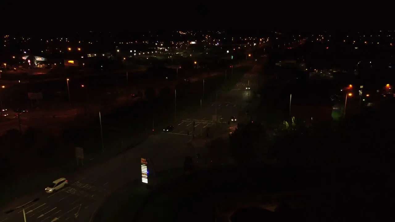 Nighttime traffic headlights driving British town highway intersection aerial view