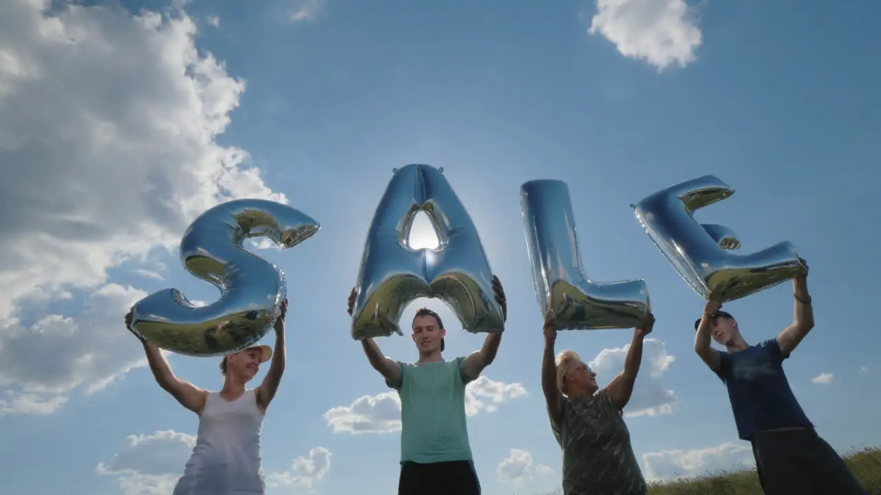 Several People Hold Balloons In The Form Of Letters Make Up The Word Sale 4K Video