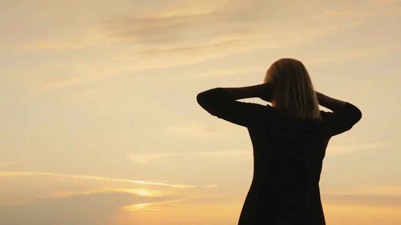 Silhouette Of A Woman Looking At The Sky After Sunset Back View