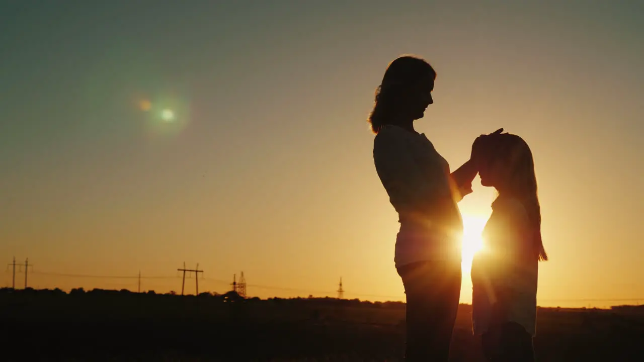 Mother Caresses Her Daughter Gently On The Head At Sunset Mom With A Baby Concept 4K Video