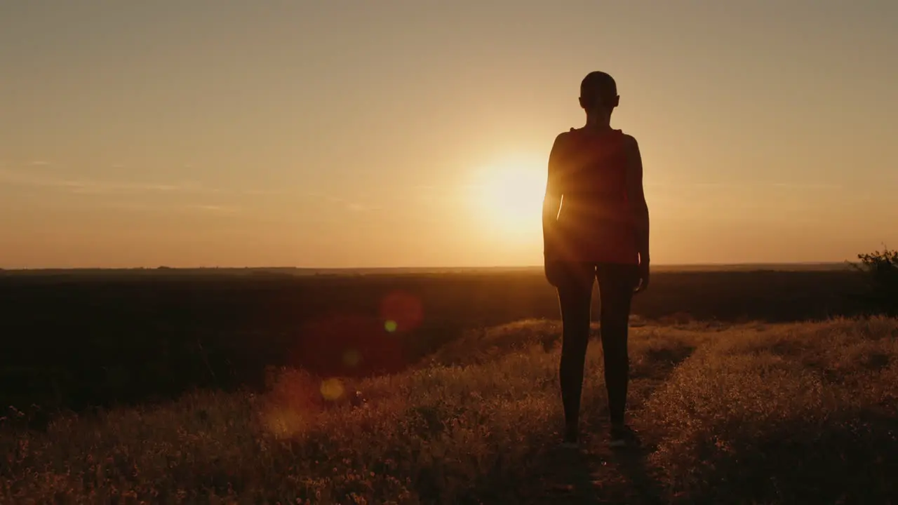 Slender woman silhouette in the setting sun 1