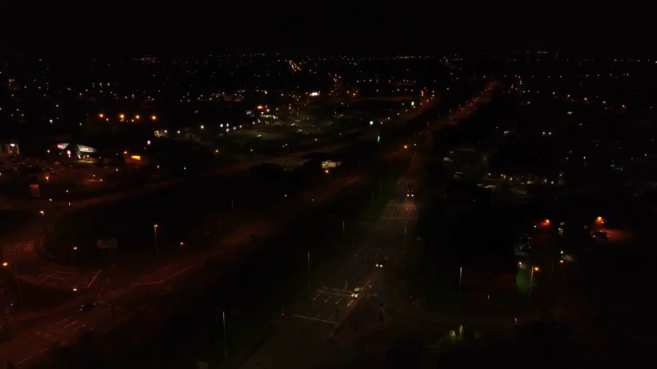 Nighttime traffic headlights driving rural British town highway intersection aerial view