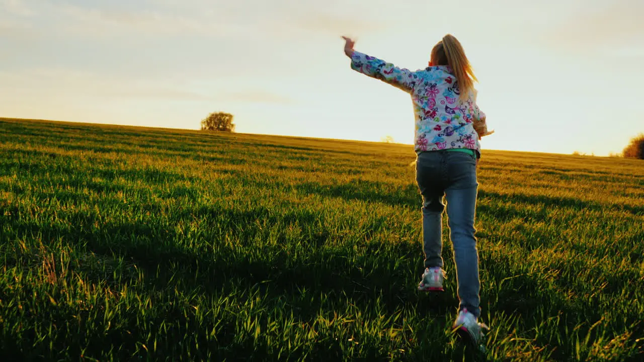 A Little Girl Runs Across The Field Like An Airplane 1