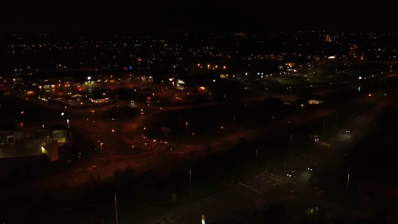 Nighttime traffic headlights driving dark British town highway intersection aerial view