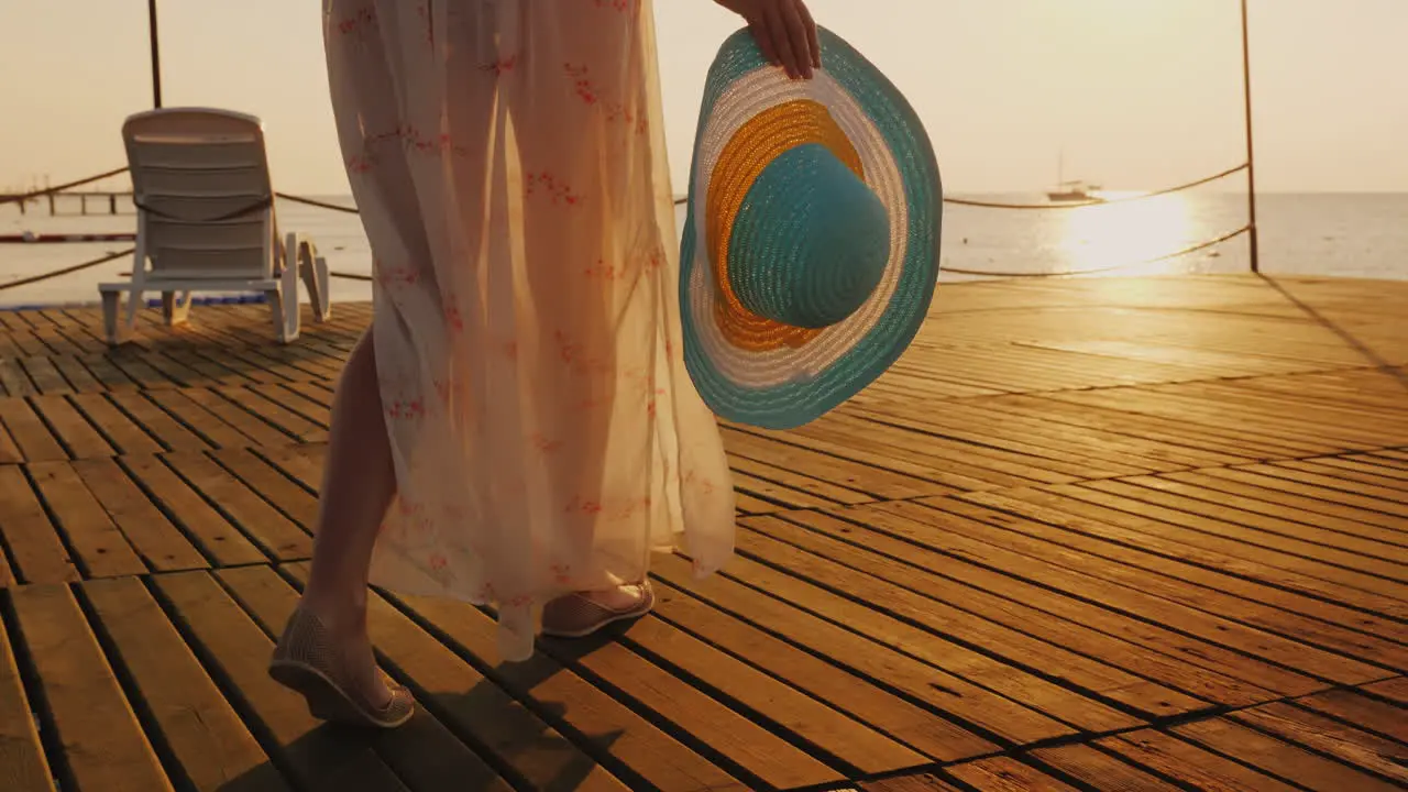 A Woman Walks The Pier Towards The Rising Sun In The Picture You Can See A Hand With A Hat Travel An