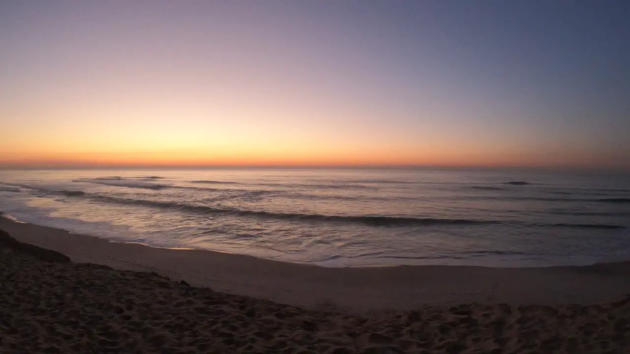 Sunset over waves in Maceda beach in Portugal