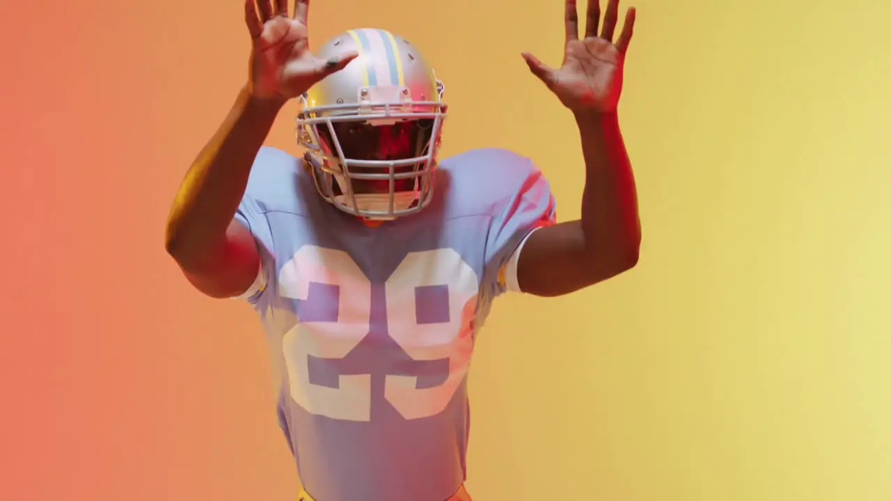 Video of african american american football player over yellow to orange background