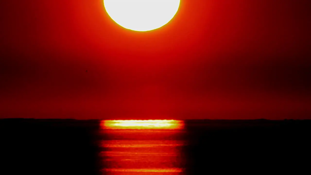 Time lapse of a huge orange sunset ball setting