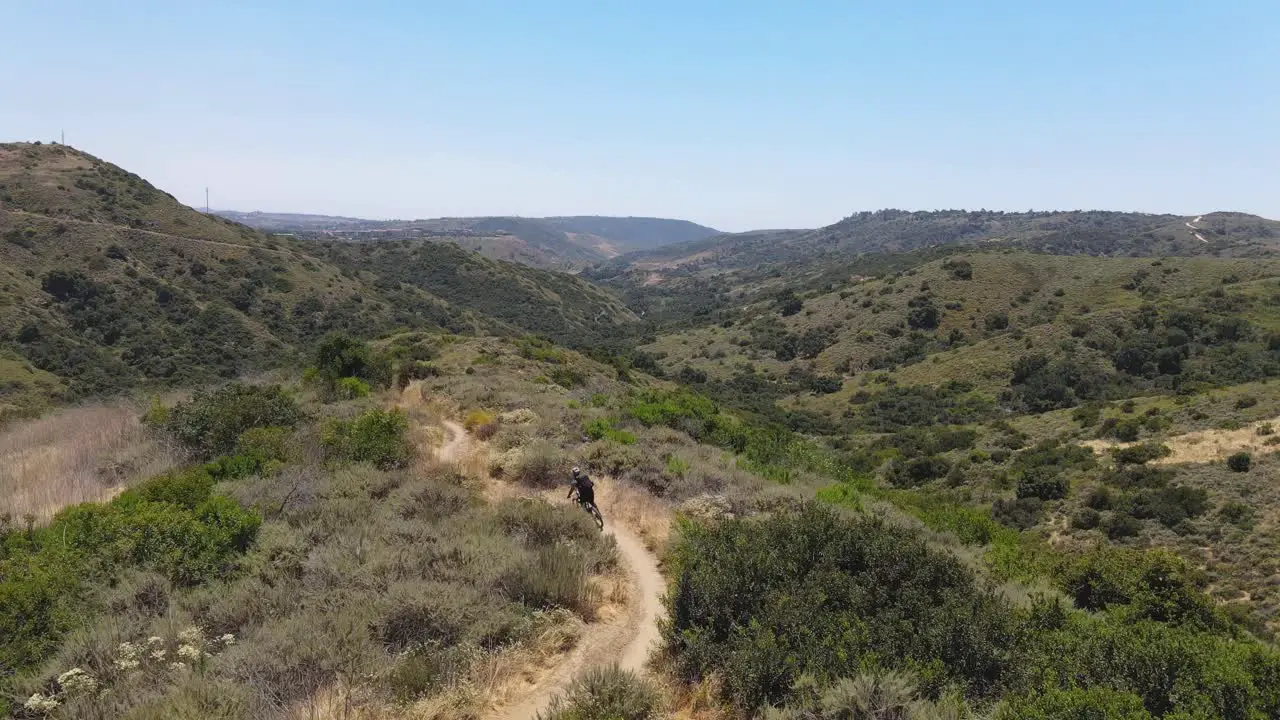 Drone shot of mountain biker on mountain trail