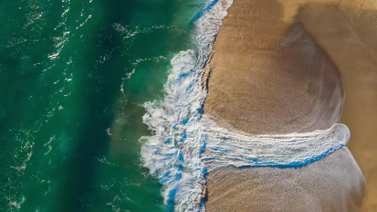 Cenital view of the sea and the waves on a spring day blue green and orange combinatios