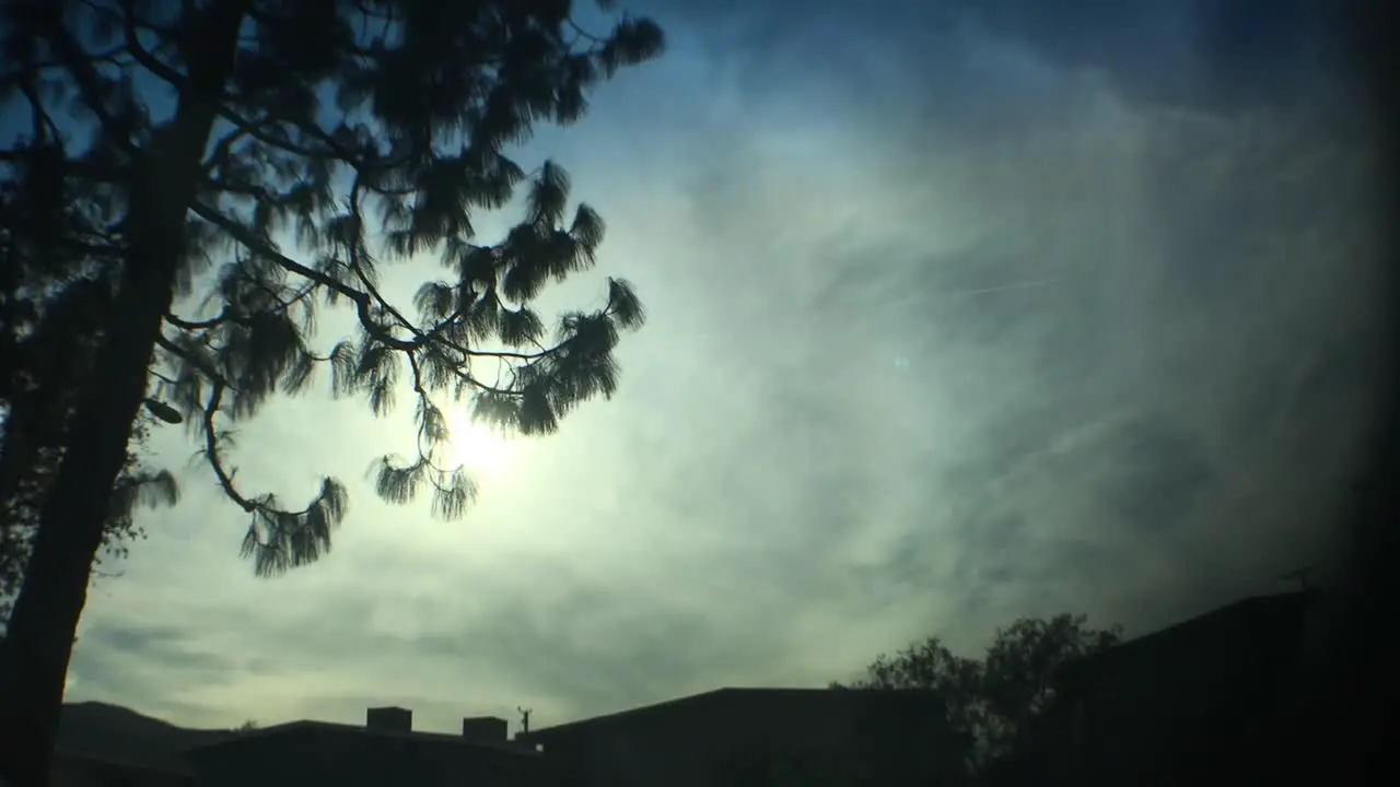 Dark dramatic clouds sky motion behind tree silhouette in autumn morning nature Time lapse