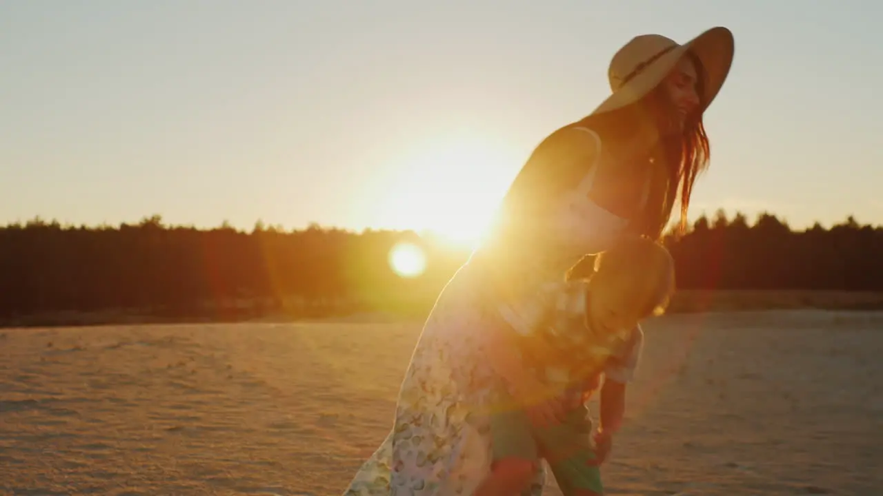 Young Mother With Long Hair Playing With His Son At Sunset Fun Turns It Around