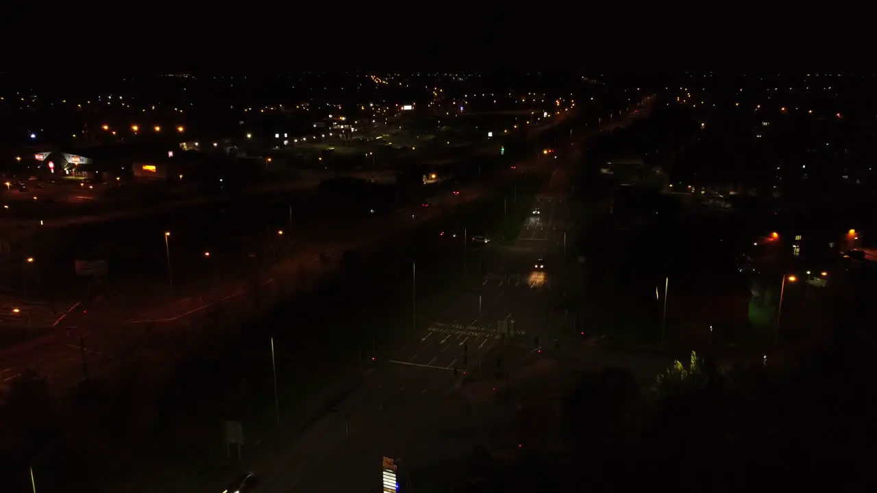 Nighttime traffic headlights driving British town highway roads aerial view