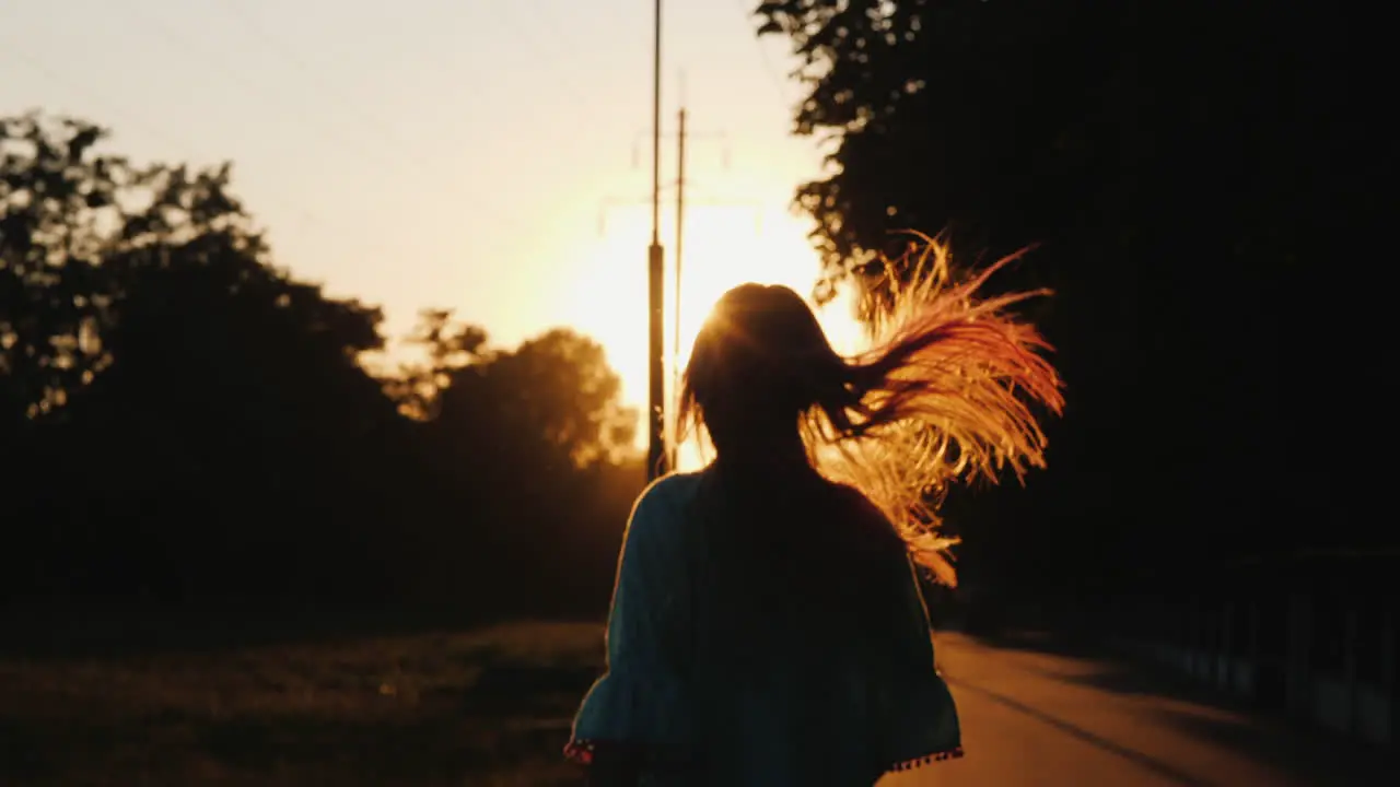 Silhouette Of A Girl Having Fun Running Down The Alley In The Rays Of The Setting Sun