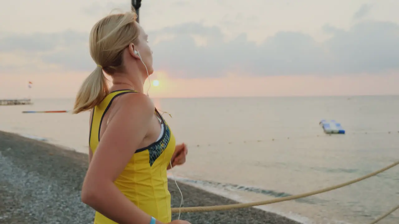 Active Way Of Life A Young Girl In Sportswear Makes A Morning Run On The Pier To Meet The Sunrise