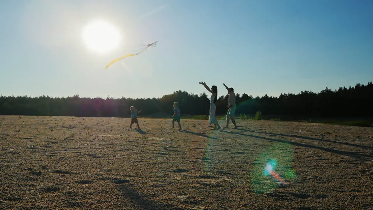 Young Family Mom Dad And Two Sons Are Playing With A Kite