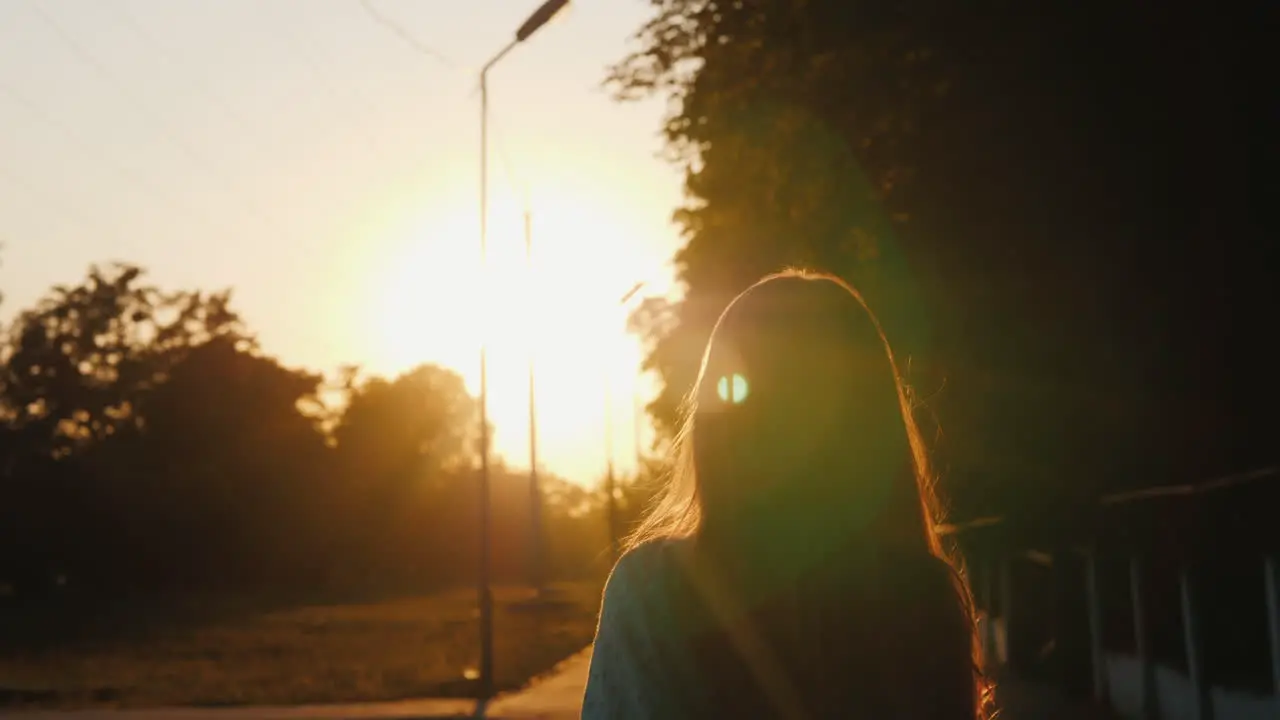 A Child Frolics On The Street In The Evening When The Sun Sets Runs And Jumps Emotionally