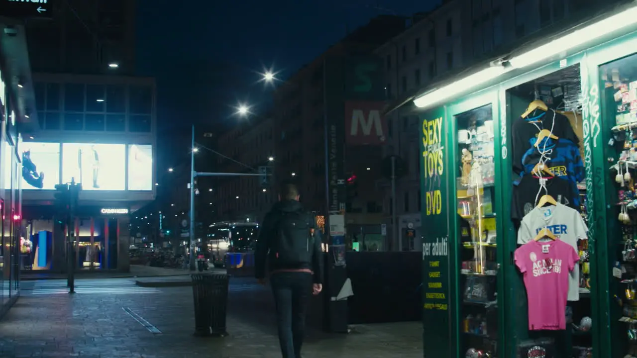 Man walks at night towards the Milan metro