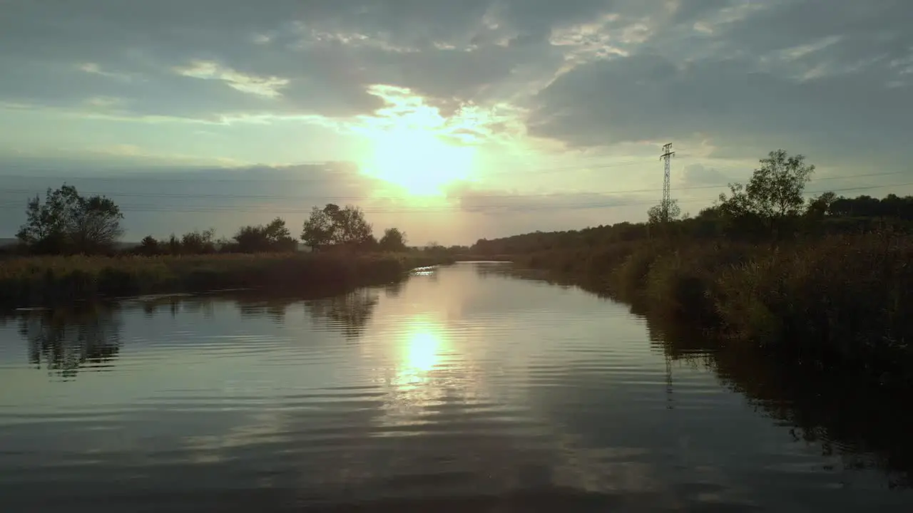 Low drone shot close to the river fly upstream at sunsey