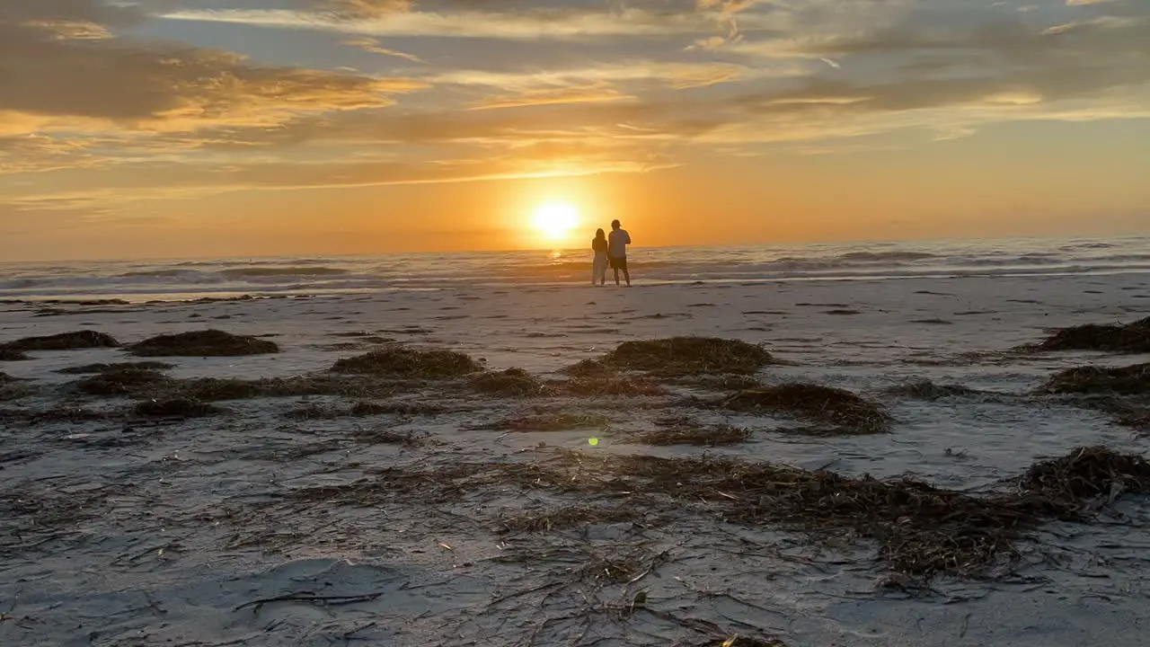 Timelapse of couple on the beach watching the sunset at St