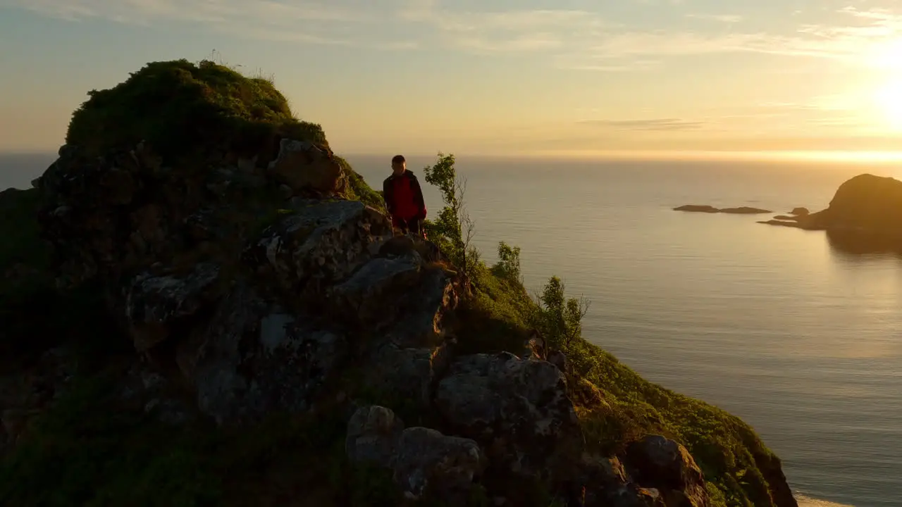 Man hiking relaxed on top of mountain with background sun and sea