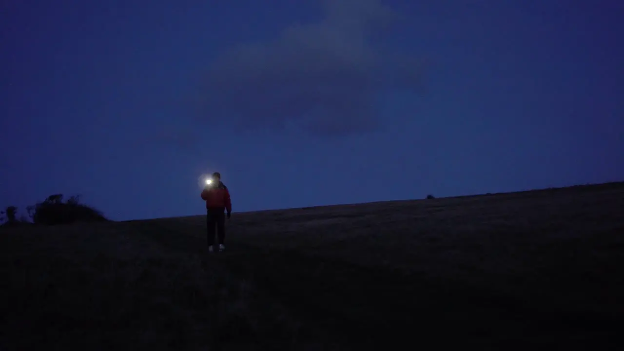 Lone Man Walking in the Countryside with a Phone Torch