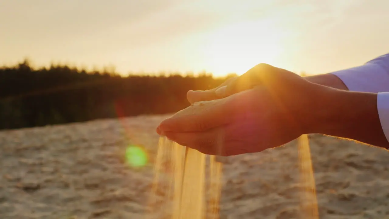 Sands slip through the hands of man in a suit 2