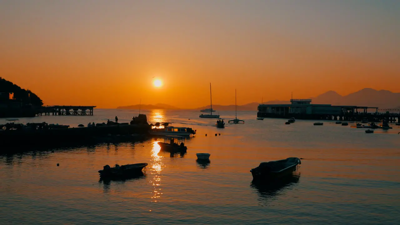 Cinematic shot of a little harbor of a little fisher village during a beautiful sunset