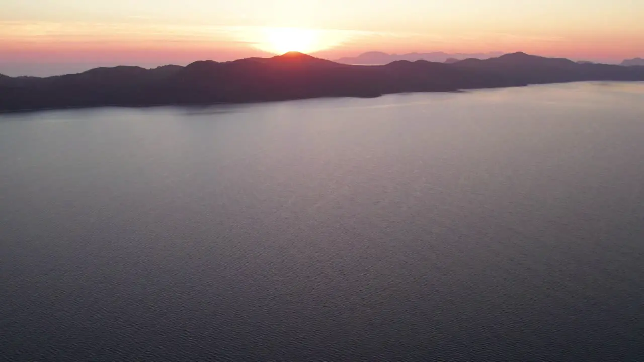 Croatian coastal island in Adriatic sea with bright fiery sunset aerial