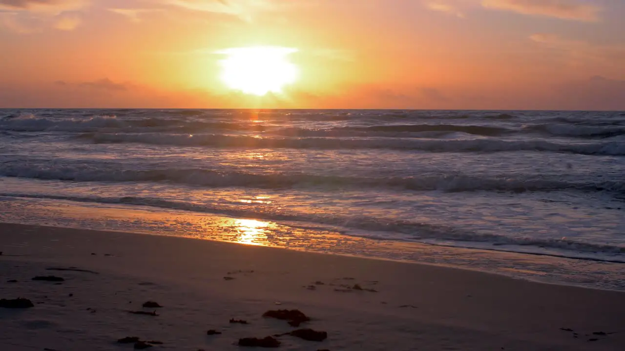 Beautiful sunset on the background of Baltic sea sun going beyond the horizon illuminating water and clouds in the sky calm sea waves romantic mood copy space wide shot