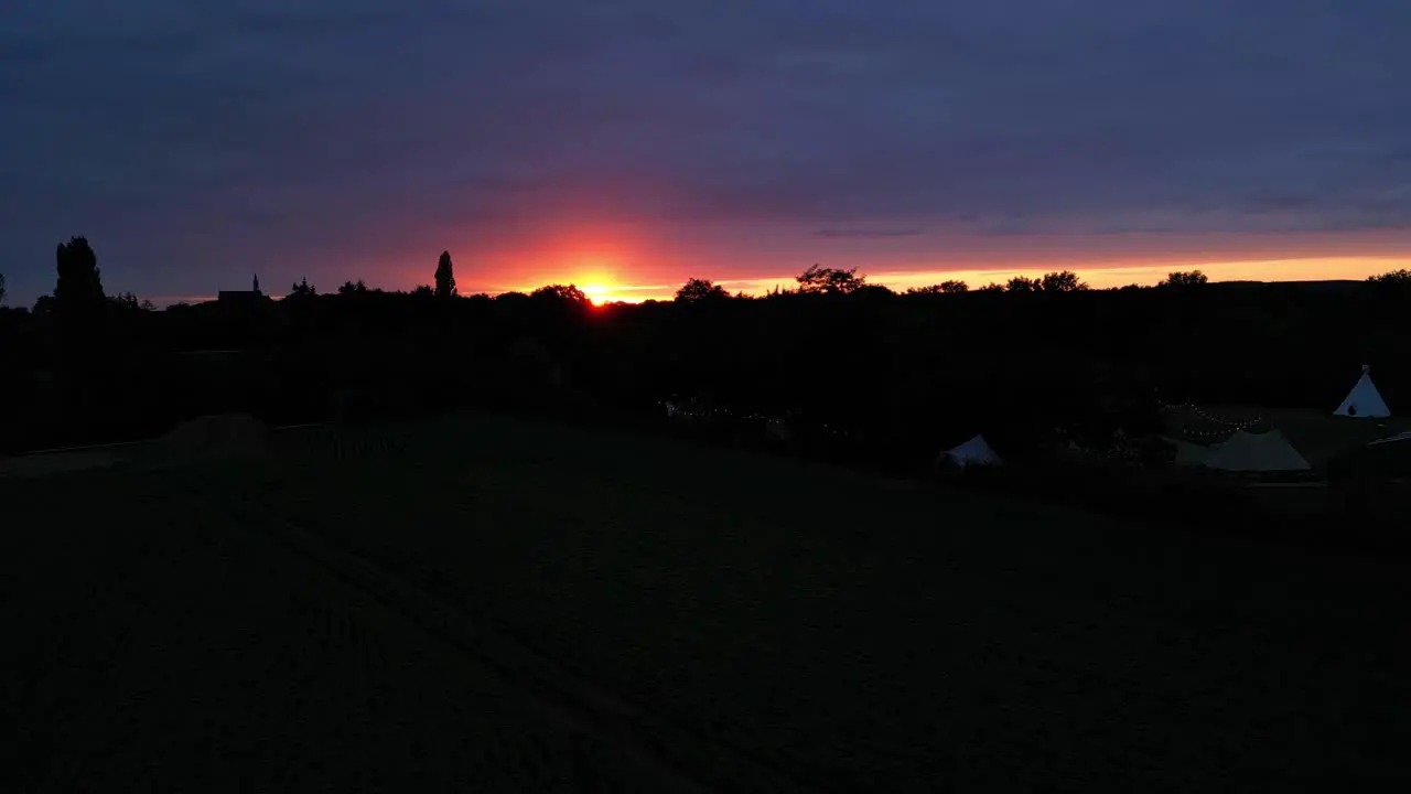 Aerial Parallax Shot Of Golden Orange Sunset Sky With Silhouette Landscape View