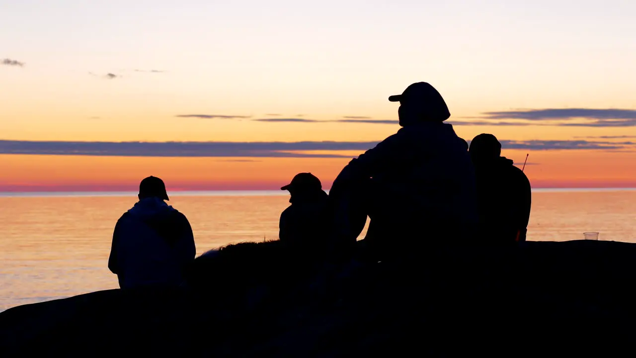 Group of friends enjoying sunset and seascape horizon view