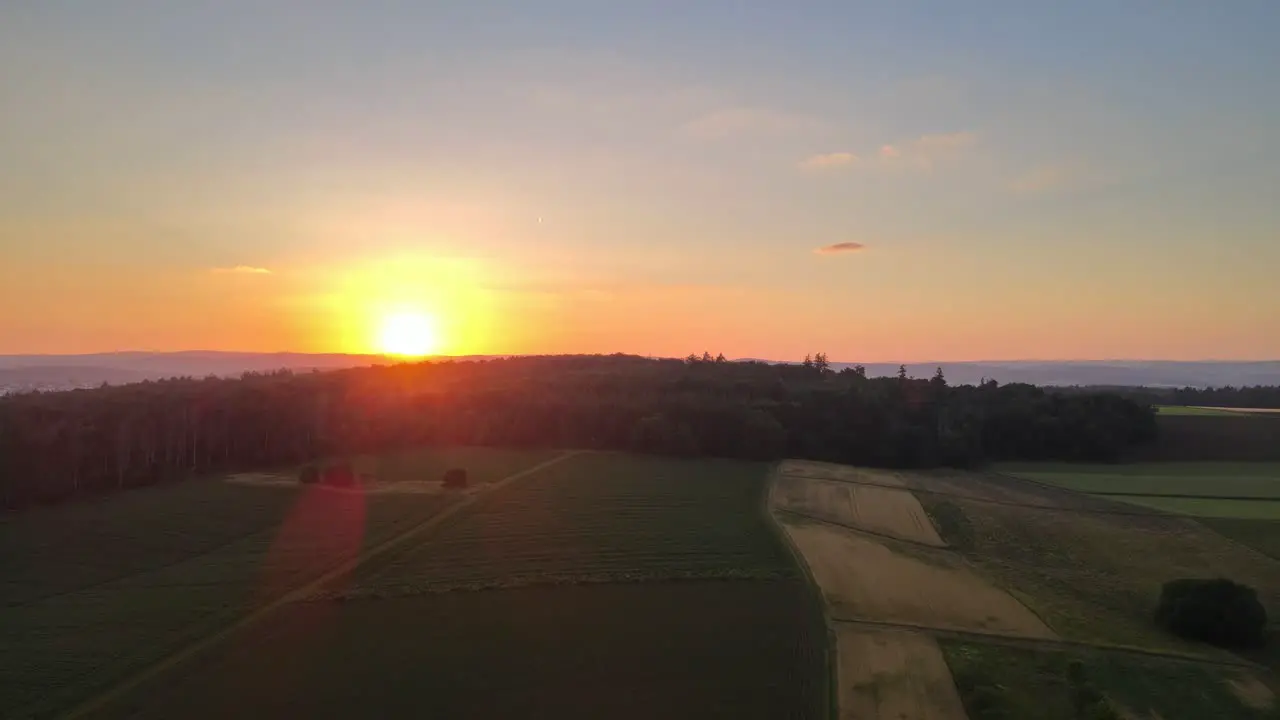 Extremely vibrant orange sunset over meadows and forests of Hesse Germany