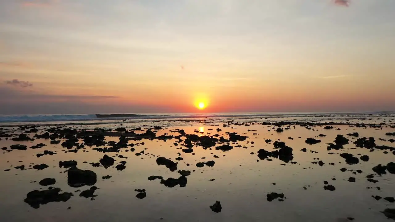 Dramatic drone shot of the coast at low tide at Gili Trawangan Bali Indonesia and sunset behind the pier