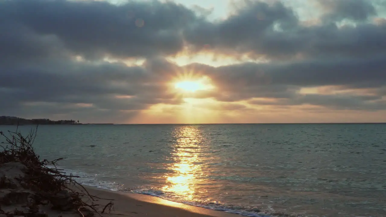 At Zorritos Beach in Tumbes Peru the sun is setting in the horizon as the water of the sea washes up at the shore