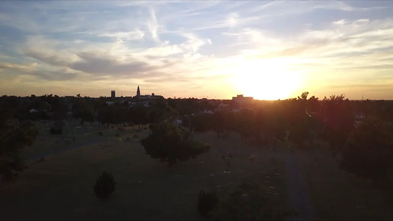 Ascending aerial shot of a graveyard with the sun setting