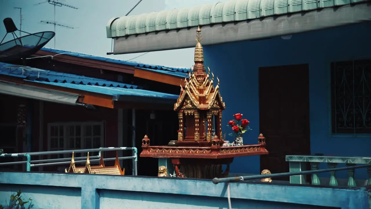 A spirit house in a front garden in Thailand